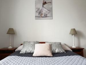 a bed with two lamps and a picture of a ballet dancer at Gościniec Rutikal in Sianów