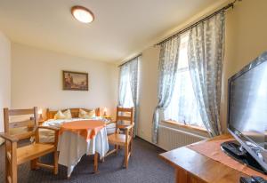 1 dormitorio con cama, mesa y TV en Hotel Świeradów, en Świeradów-Zdrój