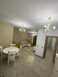 ein Wohnzimmer mit einem Tisch, Stühlen und einem Sofa in der Unterkunft Apartament Adrian-Beach Resort in Mamaia Nord – Năvodari