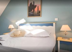 フエナンにあるResidence Cap Azur - maeva Homeのベッドルーム1室(白いベッド1台、テーブル2台、ランプ2つ付)