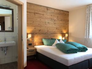 a bedroom with a bed with a wooden wall at Haus Sonneneck - ski in & out in Sankt Anton am Arlberg