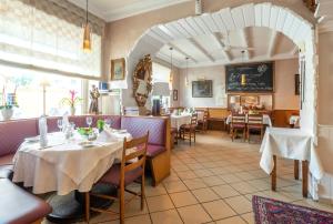 un restaurante con mesas y sillas en una habitación en Hotel Koch Schilt, en Irrel