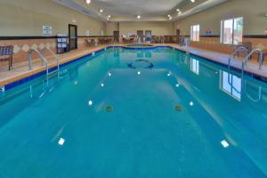 a large swimming pool with blue water at Holiday Inn Express and Suites Lubbock South, an IHG Hotel in Lubbock