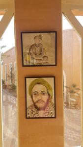 deux images encadrées d'un homme sur un mur dans l'établissement Ksar Jenna, à Nkob