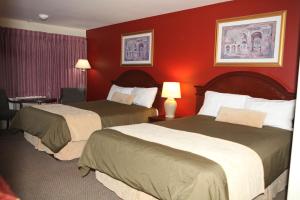 2 łóżka w pokoju hotelowym z czerwonymi ścianami w obiekcie Saxony Motel w mieście Chatham
