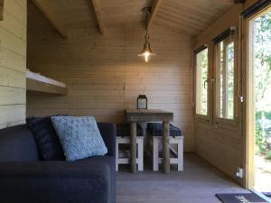 Habitación con sofá y mesa en una cabaña de madera. en Cozy Lodge near Brattforsheden nature reserve, en Filipstad