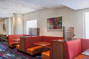 a waiting room with red chairs and tables at Holiday Inn Express Hotel & Suites Fisherman's Wharf, an IHG Hotel in San Francisco
