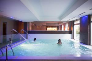 a swimming pool with two people in it at Regiohotel Manfredi in Manfredonia