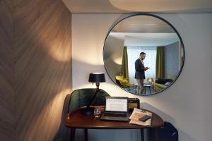 a man standing in front of a mirror in a hotel room at Carlton President in Utrecht