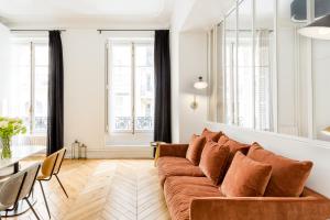 Appartement Echelle في باريس: غرفة معيشة مع أريكة وطاولة