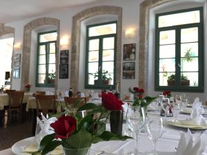 ein Esszimmer mit einem Tisch mit roten Blumen darauf in der Unterkunft Hotel Televrin in Nerezine