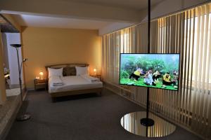 a room with a bed and a flat screen tv at Hotel Central in Timişoara