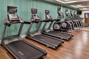 Siloam Springs的住宿－賽洛姆斯普林斯智選假日套房酒店，健身房里的一排跑步机