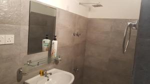 uma casa de banho com um lavatório e um espelho em COCO Rooms em Galle