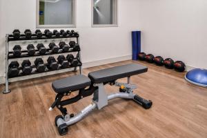 a gym with a bench and dumbbells at Holiday Inn Express & Suites - Siloam Springs by IHG in Siloam Springs +48 photos
