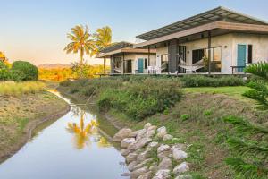 a house with a river in front of it at White Knot Khao Yai in Ban Khanong Phra Nua