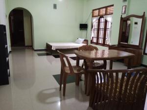 a room with a table and chairs and a bed at Sunny Side 89 in Galle