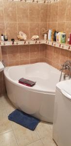 une baignoire blanche dans une salle de bain avec un lavabo dans l'établissement miły pokój niedaleko centrum i starego miasta, à Varsovie