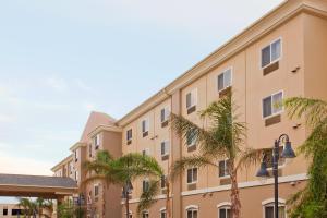 a building with palm trees in front of it at Holiday Inn Express Hotel & Suites Los Angeles Airport Hawthorne, an IHG Hotel in Hawthorne