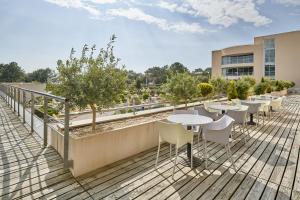 a balcony with tables and chairs on a building at Club Vacances Bleues Les Jardins De l'Atlantique in Talmont