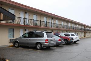 Une rangée de voitures garées dans un parking en face d'un bâtiment dans l'établissement Saxony Motel, à Chatham
