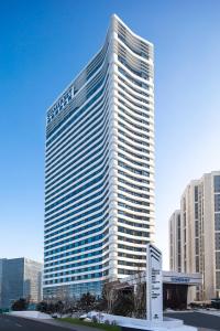 a tall building with a sign in front of it at Somerset Zhongmao Changchun in Changchun