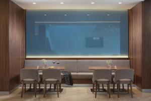 a dining room with four chairs and a large window at Hotel Milan in Pula