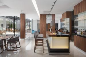 a kitchen with a bar and some chairs and tables at Hotel Milan in Pula