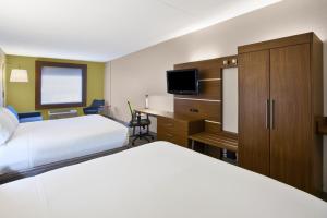 a hotel room with two beds and a desk at Holiday Inn Express Hotel & Suites Manchester Conference Center by IHG in Manchester +34 photos