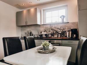 a kitchen with a table with black chairs and a counter at Xenos Apartments in Willingen +37 photos