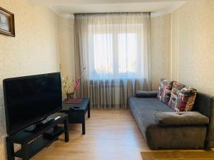uma sala de estar com um sofá e uma televisão de ecrã plano em Apartment 3 em Kislovodsk