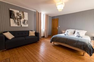 1 dormitorio con 1 cama y 1 sofá en La ferme de Fumichon, en Tour-en-Bessin