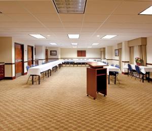 a large room with tables and chairs and a podium at Lexington Inn and Suites in Lexington
