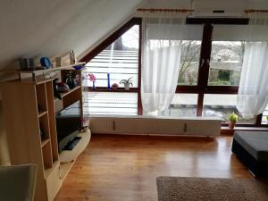 ein Wohnzimmer mit einem großen Fenster mit weißen Vorhängen in der Unterkunft Hoernchens-Ferienwohnung in Neuenkirchen