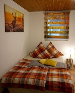 a bedroom with a bed with a plaid blanket and a window at Ferienwohnung Rothirsch in Bad Sachsa