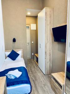 una camera da letto con un letto con cuscini blu e una TV di Motel Blue a Berlino