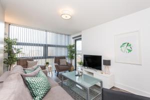 ein Wohnzimmer mit einem Sofa und einem TV in der Unterkunft Host & Stay - Standish Street Place in Liverpool