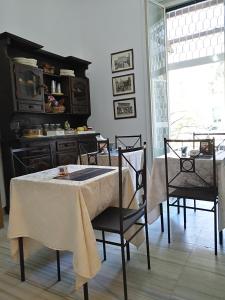 a dining room with a table and chairs and a kitchen at Tucci's Roma Guest House in Rome