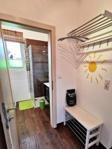 ein Badezimmer mit einer Bank und einer Sonne an der Wand in der Unterkunft Apartment Sonne in Waidhofen an der Thaya