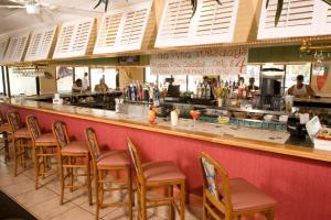 bar z drewnianymi stołkami w restauracji w obiekcie Ocean Breeze Inn Vero Beach w mieście Vero Beach
