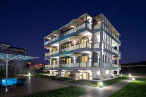 a large white building with a pool at night at Astra Sarti Luxury Suites in Sarti