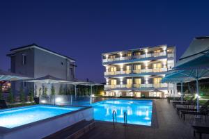 a hotel with a swimming pool at night at Astra Sarti Luxury Suites in Sarti