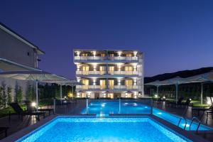 a hotel with a swimming pool in front of a building at Astra Sarti Luxury Suites in Sarti