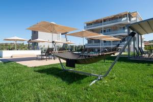 a swing in the grass in front of a building at Astra Sarti Luxury Suites in Sarti