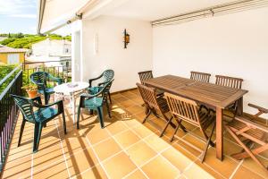 patio con mesa de madera y sillas en el balcón en El Niu, en Calella de Palafrugell