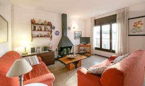 sala de estar con 2 sofás naranjas y TV en El Niu, en Calella de Palafrugell