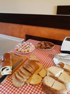a table with bread and pastries on a table at Casa Agnes Vendeghaz in Fîntînele