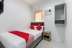 a bedroom with a bed with red pillows at Super OYO 515 Finnex Hotel in Manila