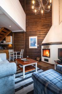 a living room with a couch and a fireplace at Lapland Hotels Bear´s Lodge in Sinettä