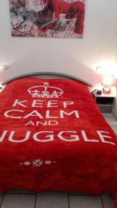 - une couverture rouge au-dessus d'un lit dans l'établissement Cap d'Agde Naturist Villa Port Nature, au Cap d'Agde